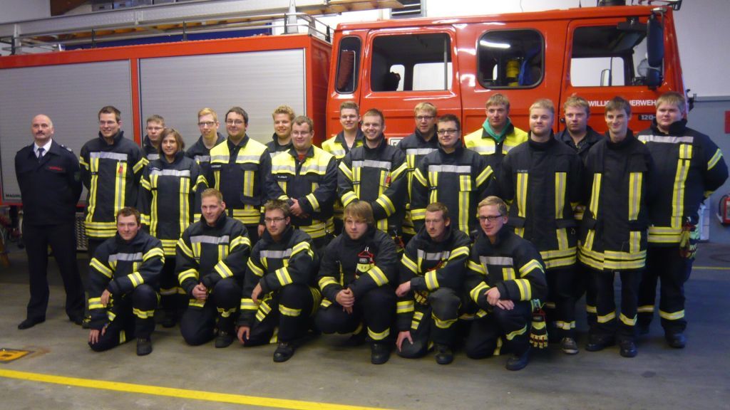 Der Ausbildungsleiter und stellvertretende Leiter der Feuerwehr, Werner Geueke (links), mit den 22 Absolventen. von Barbara Sander Graetz