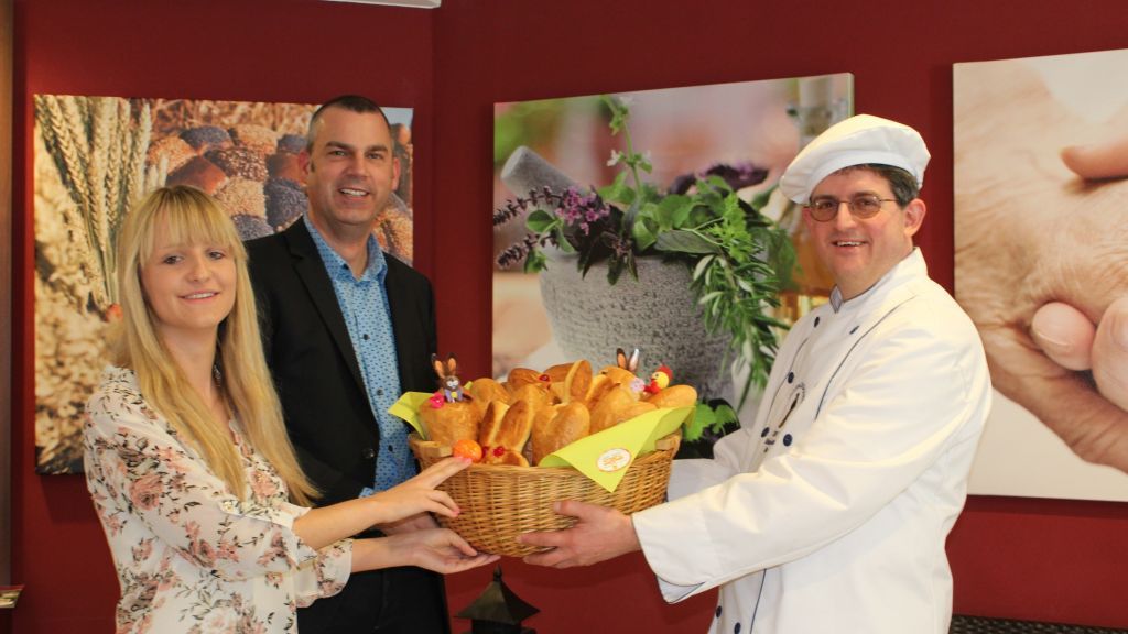 Bäckermeister Andreas Zinke (rechts) übergab eine Kostprobe der Ostersemmeln an die Zentrumsleiter Heiko Bösing und die Marketing-Beauftragte Caterina Breuer.