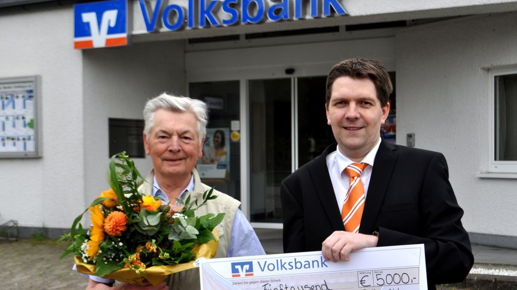Kundenberater Frank Schmidt  überreichte Otto Breuer 5.000 Euro in bar.