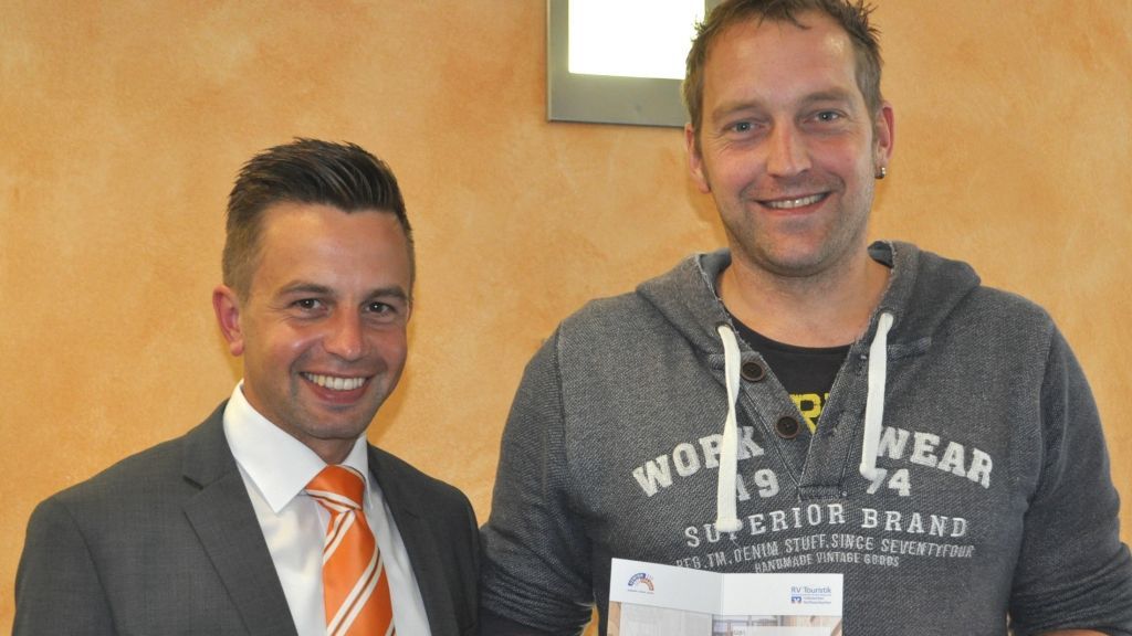 Kundenberater Tim Willmes (links) übergab einen Reisegutschein in Höhe von 1250 Euro an Sven Stracke aus Herpel. von Volksbank Olpe-Wenden-Drolshagen