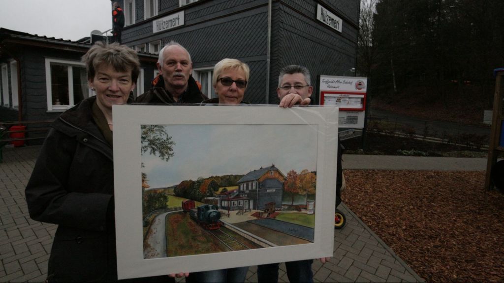 Künstlerin Elke Koch (2. v. re.) überreichte den Vertretern des Dorfvereins ein Bild vom Hützemerter Bahnhof. von Rüdiger Kahlke