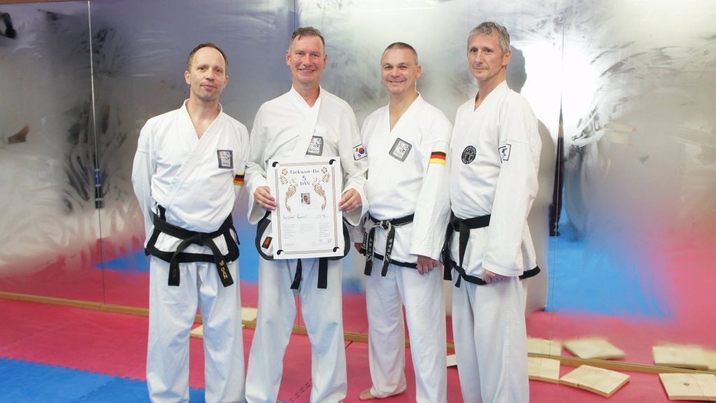 Schulleiter Kunibert Quast (2. v. l.) freut sich über die bestandene Prüfung zum Großmeister im Taekwondo. von Privat