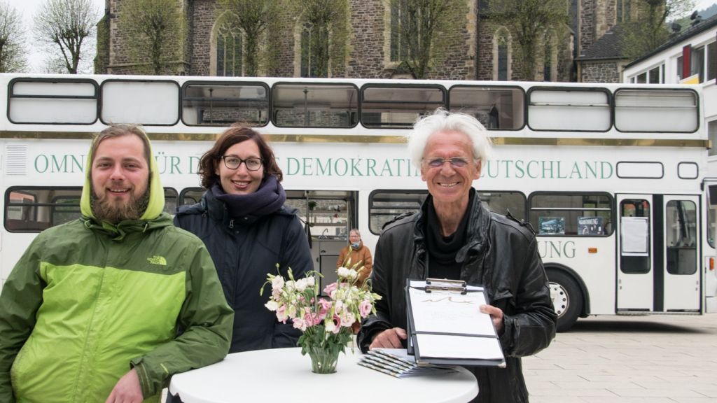 Setzen sich für eine bundesweite Volksabstimmung ein: (von links) Benjamin Radlow, Valerie Schult und Werner Küppers. Auf dem Marktplatz in Altenhundem ist außerdem Gabriele Wagener dabei (im Hintergrund). von Sven Prillwitz