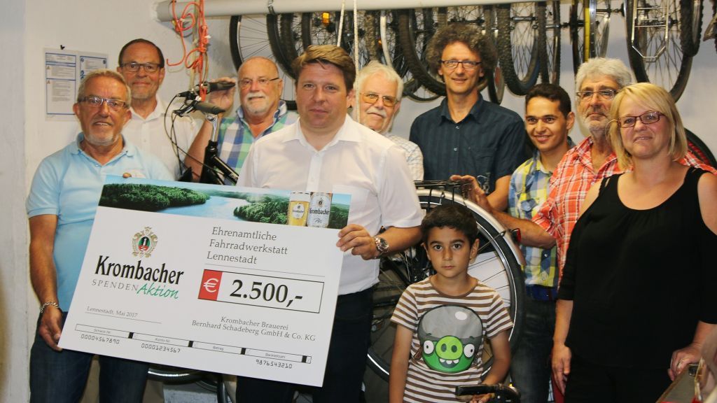 Jens Selter (4. von links) übergab im Namen der Krombacher Brauerei einen Scheck an die ehrenamtliche Fahrradwerkstatt Lennestadt. von Christine Schmidt