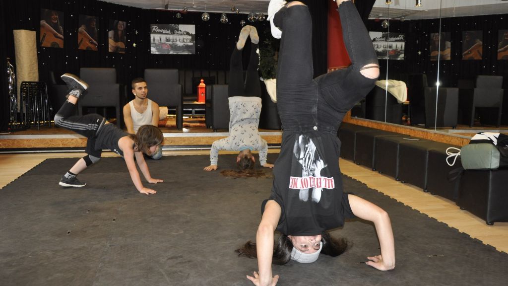 Zwei Trainer bringen den Jugendlichen die richtige Bewegung bei Breakdance bei. von kjk-Haus