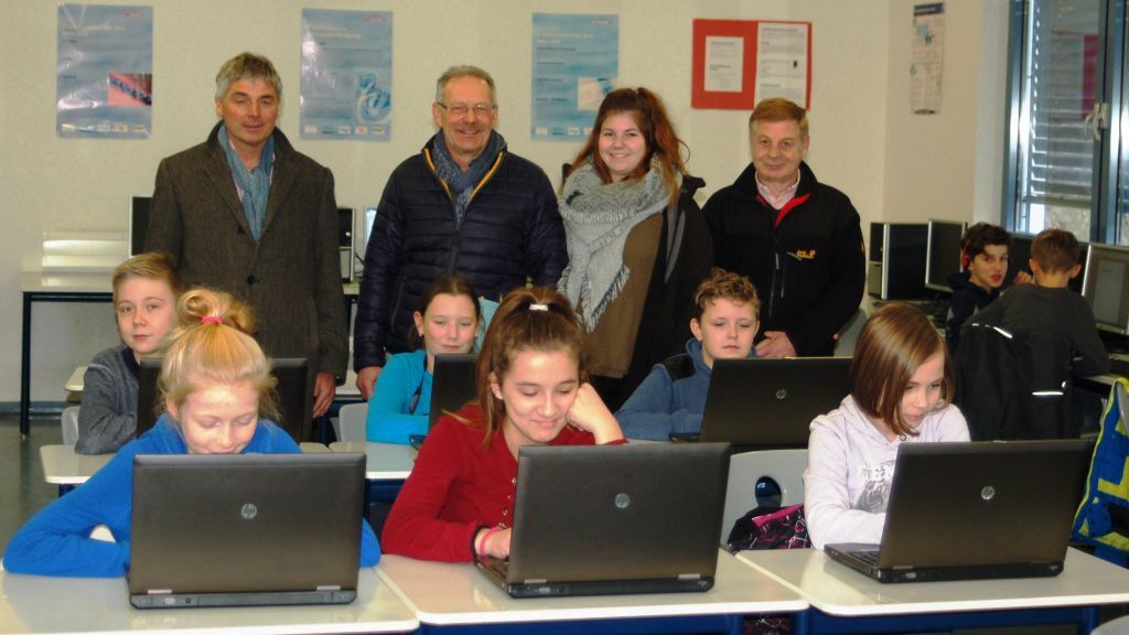 Schüler der Jahrgänge 5 und 6 in einem Informatikraum der Schule bei der Inbetriebnahme der Laptops und die Überbringer (von links: Helmut Schnell, Roland Six, Marina Rath, und Gerd Müller) des Weihnachtsgeschenkes. von privat