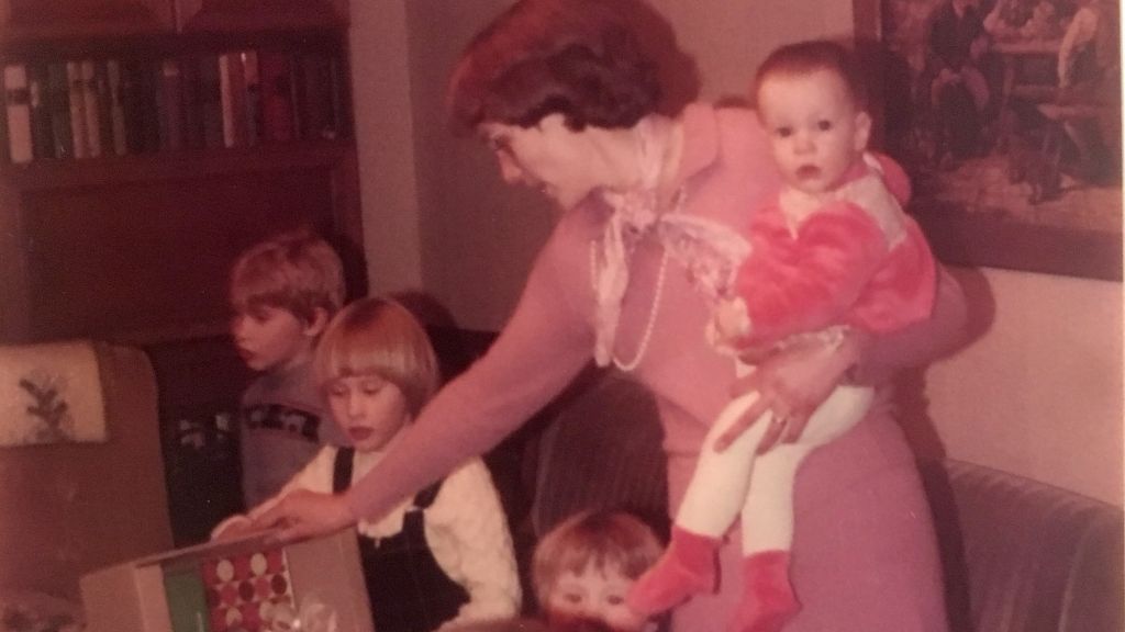 Theresa Püttmann schreibt zu dem Bild: „Zu sehen sind meine Tante Maria mit mir auf dem Arm, mein Vetter Christoph, meine Cousinen Verena und Kerstin und meine Schwester Barbara beim Geschenke auspacken bei Oma und Opa. Wir waren zu der Zeit insgesamt sieben von später acht Enkelkindern.“ von Theresa Püttmann