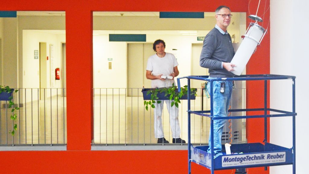 Können sich nach dem großen Umbau erstmal wieder „höheren Dingen“ zuwenden: Thomas Kaufmann (rechts) und sein Kollege Ralf Fecker kümmern sich um alle technischen Belange der Klinik, hier die Deckenlampen im Foyer. von Helios Klinik