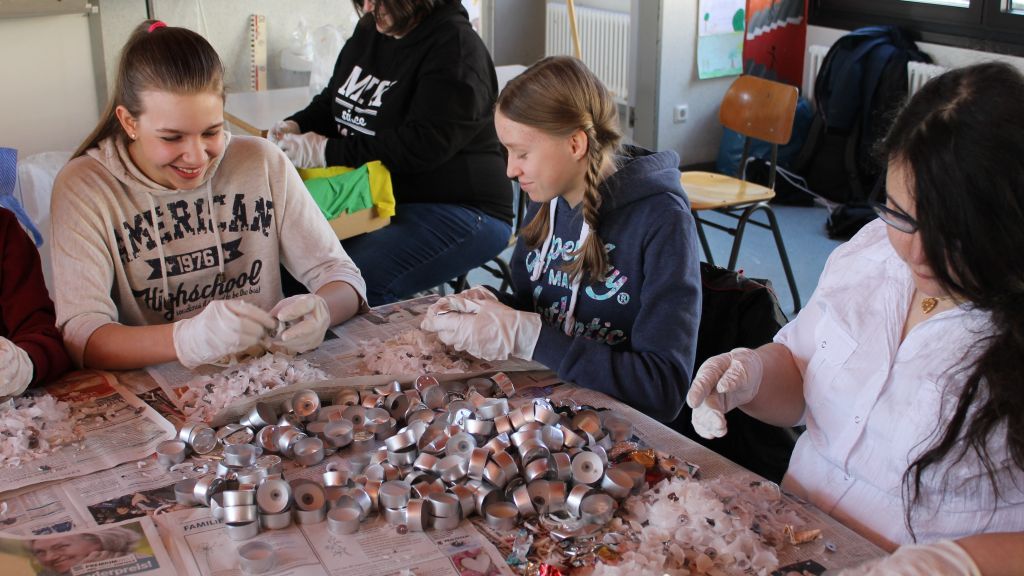 Die Schüler des Gymnasiums Maria Königin sortieren und reinigen Teelichthalter und anderes Aluminium. von privat