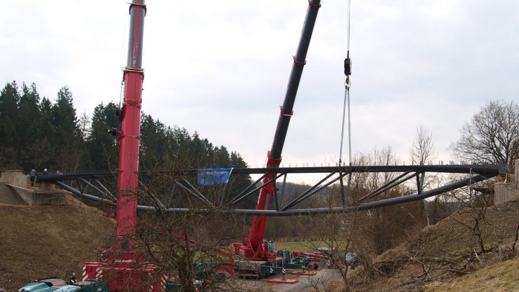Maßarbeit binnen 15 Minuten: Zwei jeweils 250 Tonnen schwere Spezialkräne setzen das Stahlkonstrukt für die Brücke ein. von s: Stadt Drolshagen