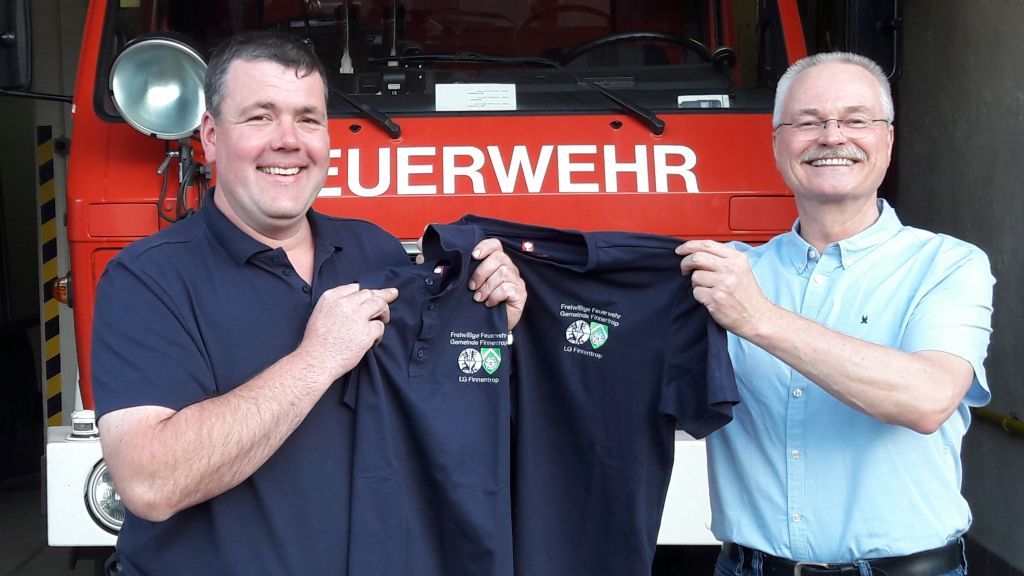 Brandoberinspektor Jörg Schäfers (links) nahm die neuen Shirts vom Vorsitzenden des Fördervereins, Markus Hesse, entgegen. von privat