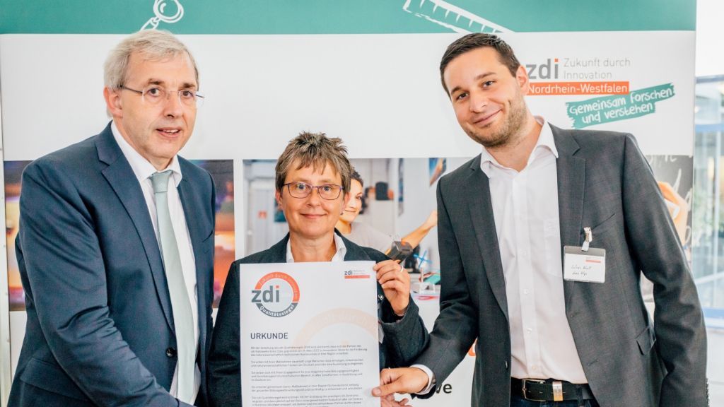Über die Auszeichnung durch Staatssekretär Klaus Kaiser (links) freuten sich Susanne Spornhauer und Lukas Kroll vom zdi-Netzwerk Kreis Olpe. von zdi-Geschäftsstelle