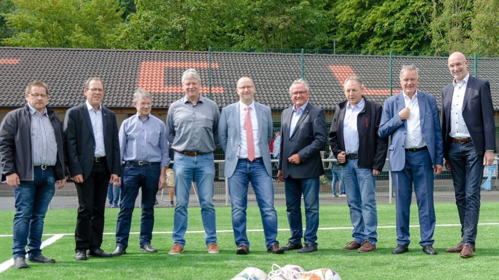 Vertreter von Sponsoren, Stadt Lennestadt, FC Lennestadt, Stadtsportverband, Kirchengemeinde und des FLVW Kreis Olpe auf dem neuen Kunstrasenplatz. von s: Nils Dinkel