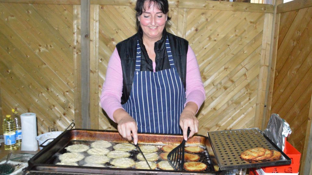 Reibeplätzchen aus frischen Kartoffeln, die beim Backen im heißen Fett der großen Pfannen schwimmen. von Barbara Sander-Graetz