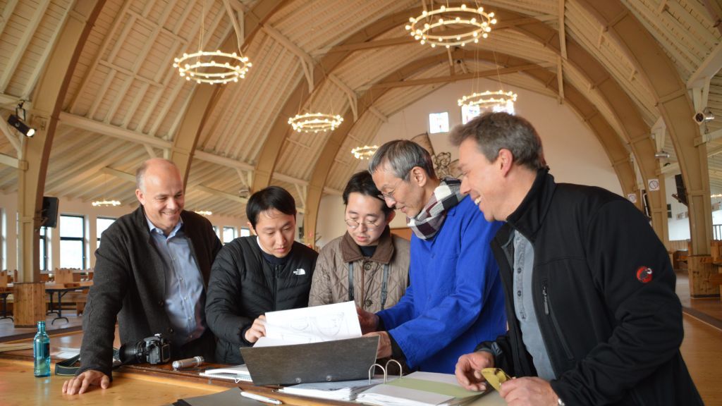Andre Zepke (links) und Jörg Sieler (rechts) zeigen Rai Sawaki, Katsuya Fukushima und Jin Motohashi (v.l.) die Baupläne der Schützenhalle Lenhausen. von Barbara Sander-Graetz