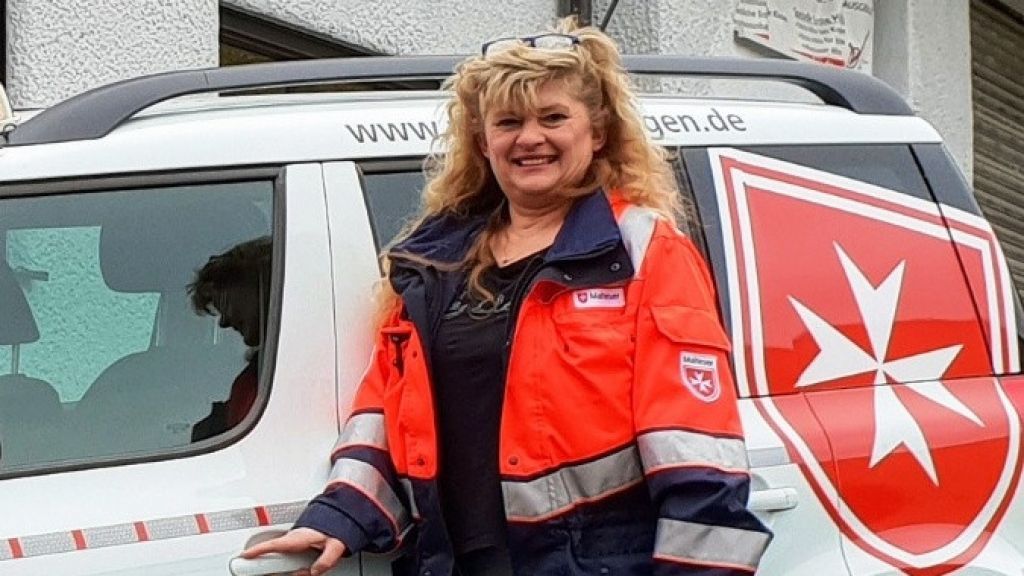 Bettina Pohl vor ihrem Einsatzfahrzeug des Malteser Hausnotruf-Bereitschaftsdienstes. von Caner/ Malteser