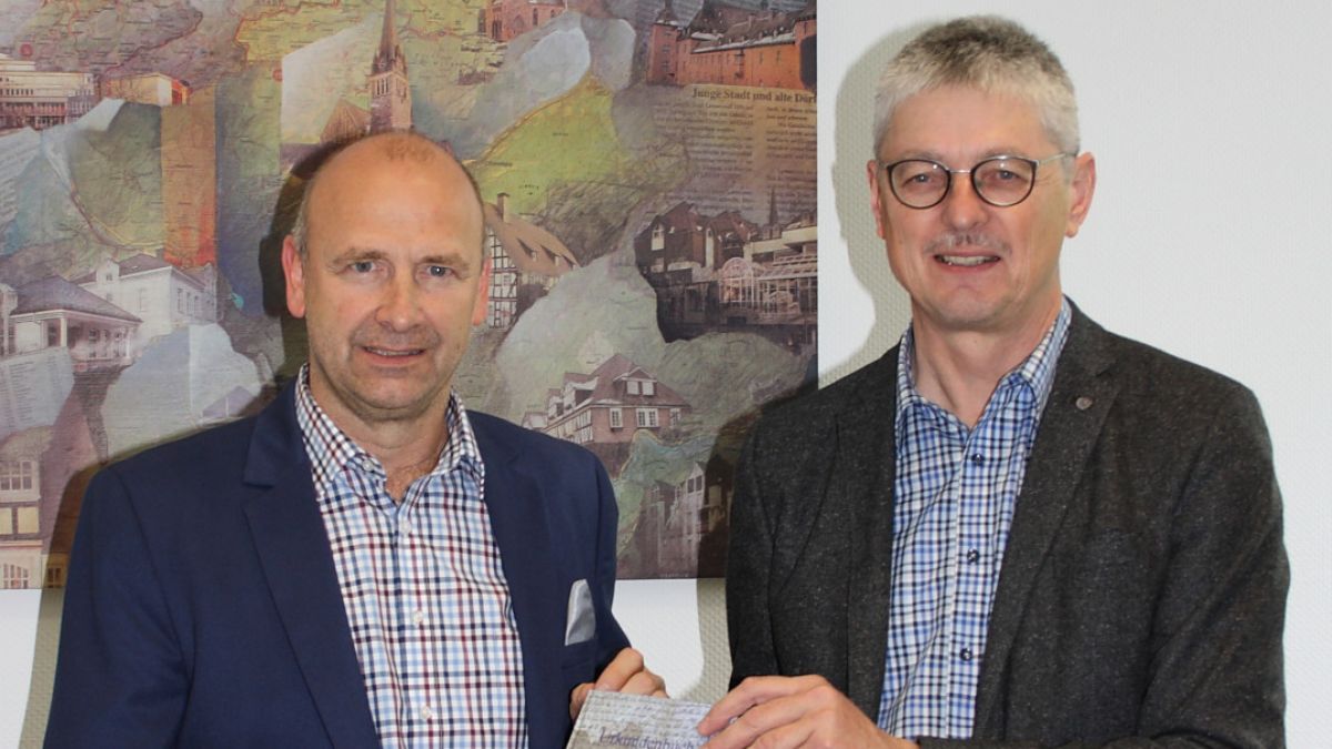 Martin Vormberg, Archivar der Gemeinde Kirchhundem, (rechts) und Bürgermeister Andreas Reinéry präsentieren ein Urkundenbuch. von Gemeinde Kirchhundem