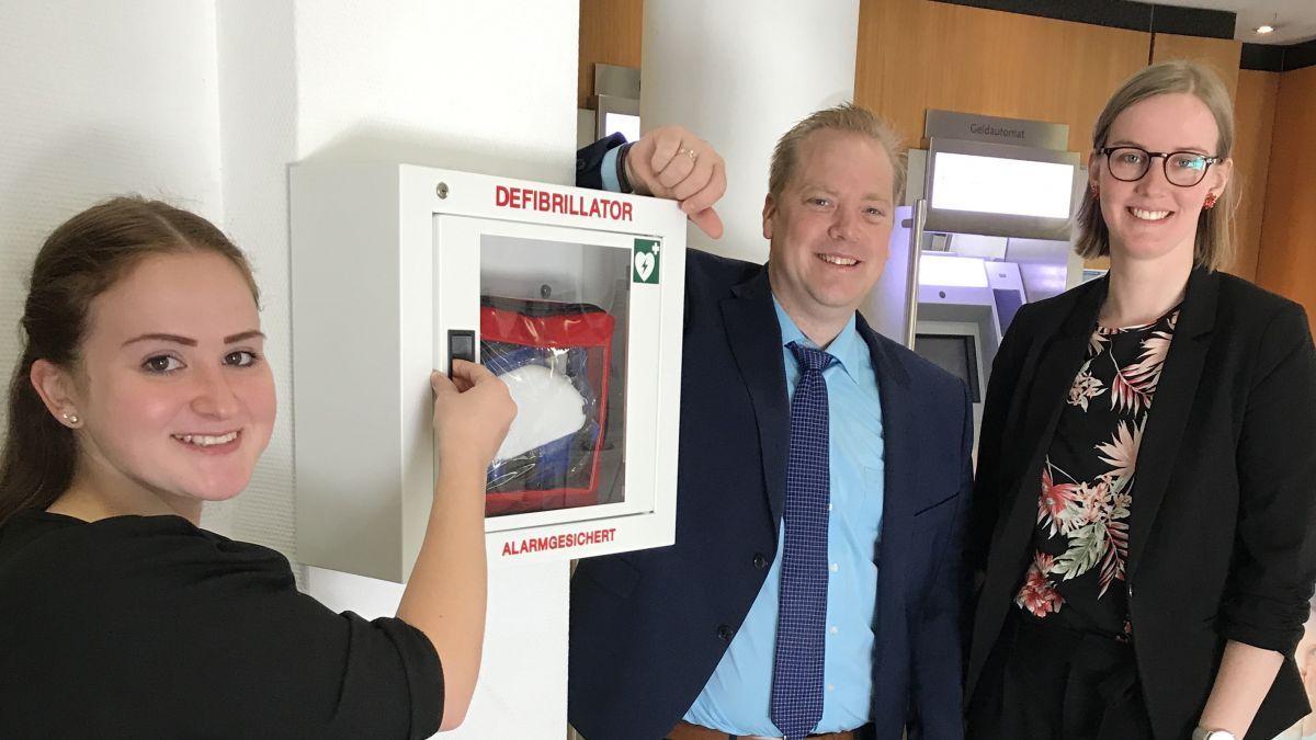 Die Serviceberaterinnen (v.l.) Angelika Schwindt und Anne Bremke sowie Privatkundenberater Martin Krömer machen ihre Kunden und Mitglieder auf den neuen Defibrillator in der Volksbank Grevenbrück aufmerksam. von privat