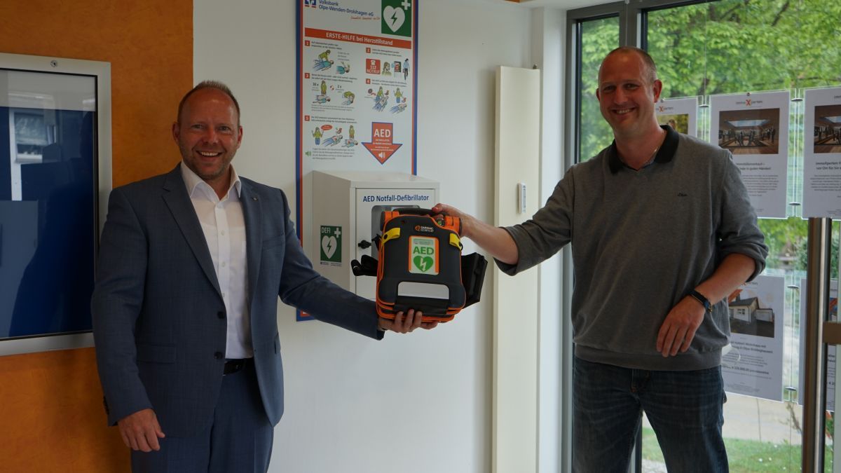 Mit Abstand übergab Volksbank-Vorstand Marco Heinemann (links) den Leben rettenden Defibrillator an den Rhoder Ortsvorsteher Jörn Dettmer. von Volksbank