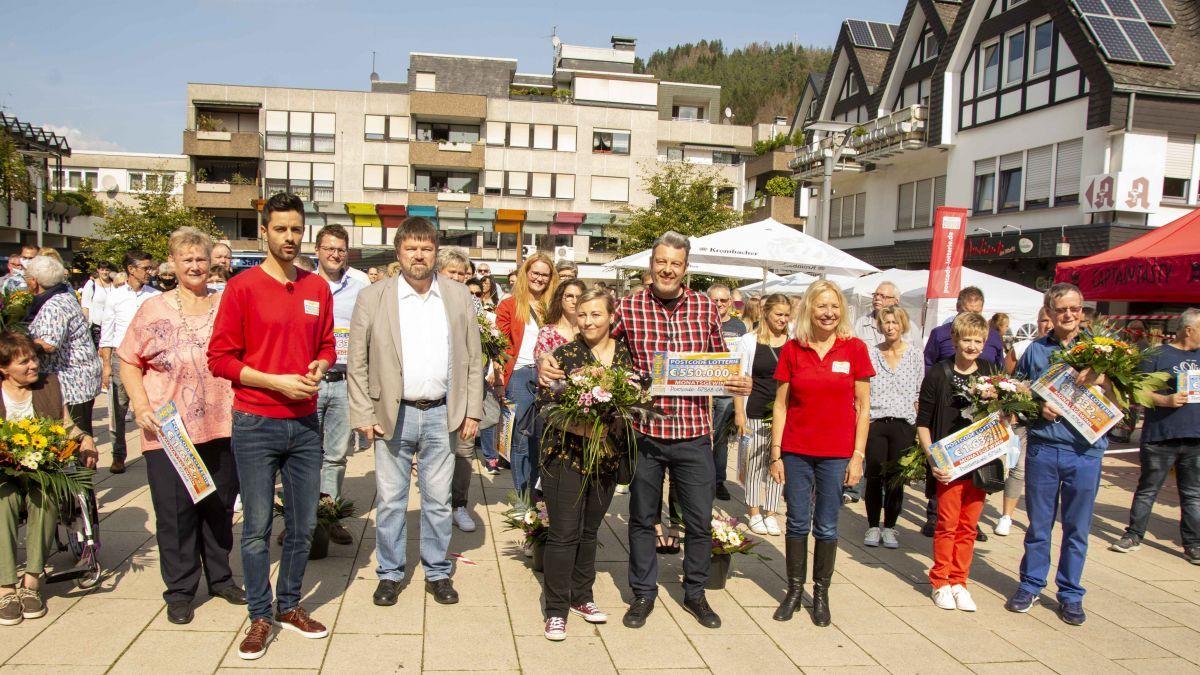 Die Deutsche Postcode Lotterie hat neben Blumensträußen auch 1,1 Millionen Euro in Form symbolischer Schecks auf dem Marktplatz in Altenhundem verteilt. von s: Nils Dinkel