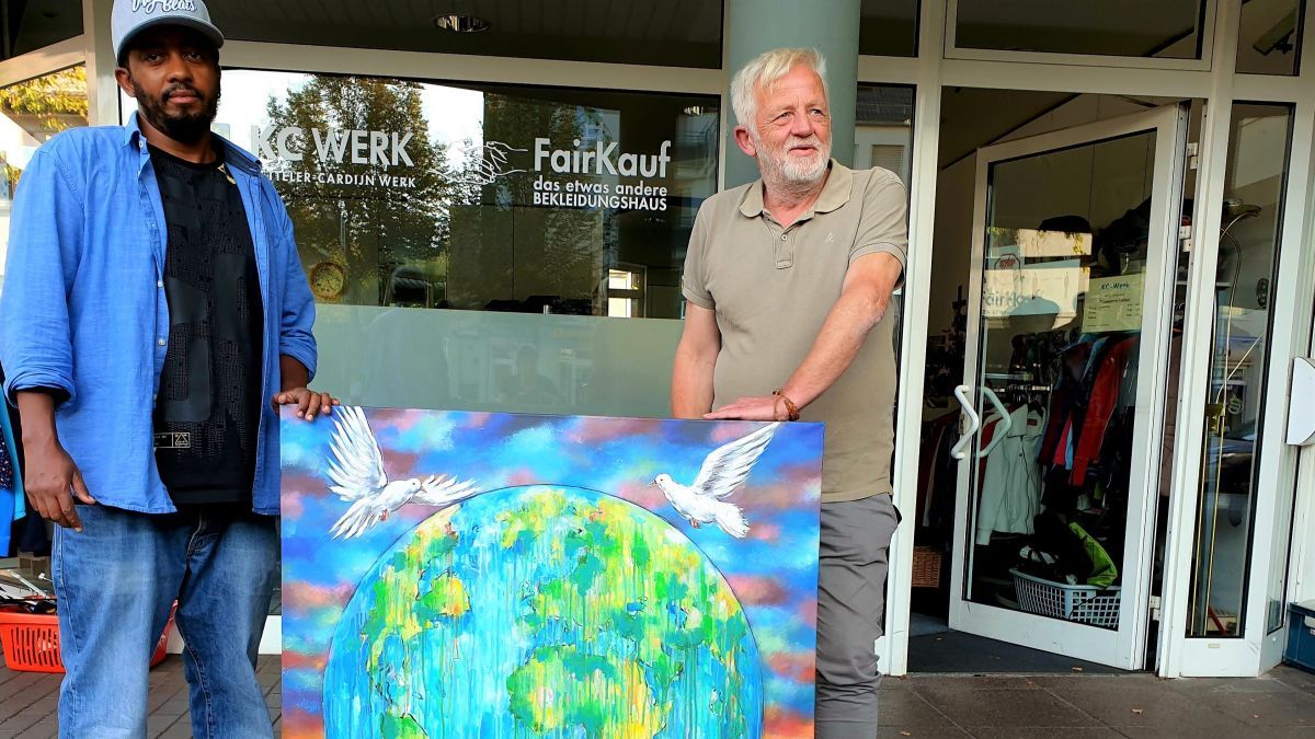 Sami Gebremariam und josef Brüser (FairKauf Laden) mit dem Bild, das versteigert werden soll. von privat