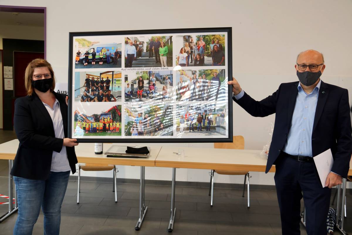 Nora Eckert überreicht eine Collage mit Fotos aller Mitarbeiter an Bürgermeister Dietmar Heß.  von privat