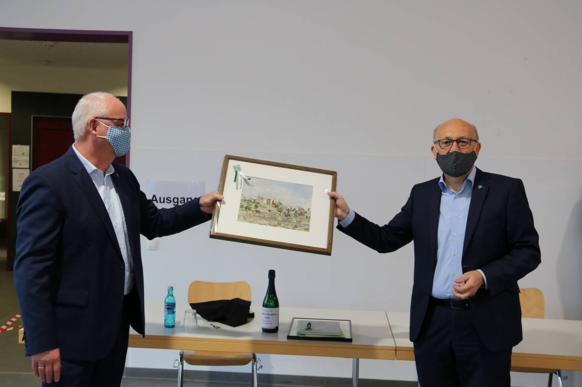 Der 1. Beigeordnete Ludwig Rasche (links) überreicht Bürgermeister Dietmar Heß zum Abschied ein Bild des malers Benno Heimes.  von privat