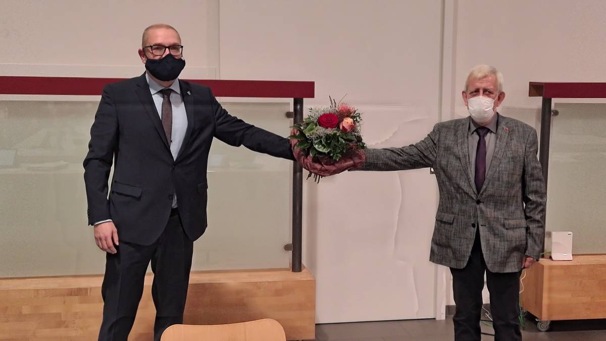 Altersvorsitzender Peter Schmitz (rechts) nimmt dem neuen Bürgermeister Achim Henkel den Eid ab und gratuliert mit einem Blumenstrauß.  von Nicole Voss