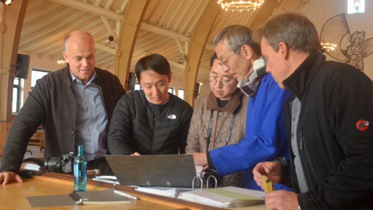 Interessiert studieren Rei Sawaki, Jin Motohashi und Katsuya Fukushima (von links), im Oktober 2018 die Baupläne der Lenhauser Schützenhalle. Daneben André Zepke (links) und Jörg Sieler (rechts).  von Nicole Voss