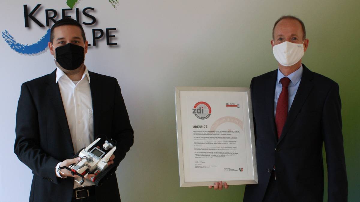 Theo Melcher (rechts) präsentiert das zdi-Qualitätssiegel und Lukas Kroll zeigt einen programmierbaren Roboter aus dem Technikunterricht. von Kreis Olpe