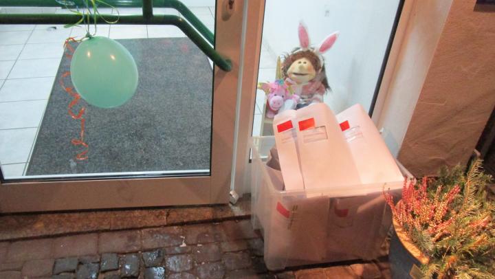 Eine Box mit Karnevalsumschläge für die Kinder steht an der Tür des Kindergattens Rönkhausen.