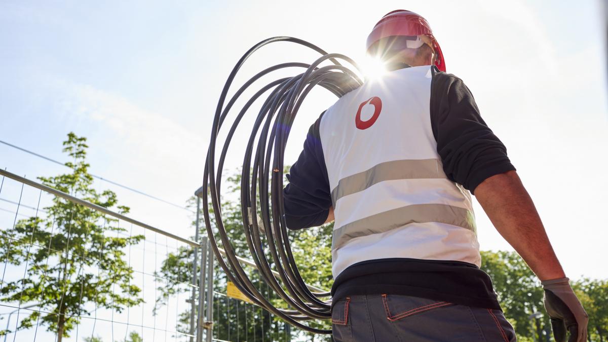 Vodafone-Mitarbeiter mit einer Kabelrolle von Vodafone
