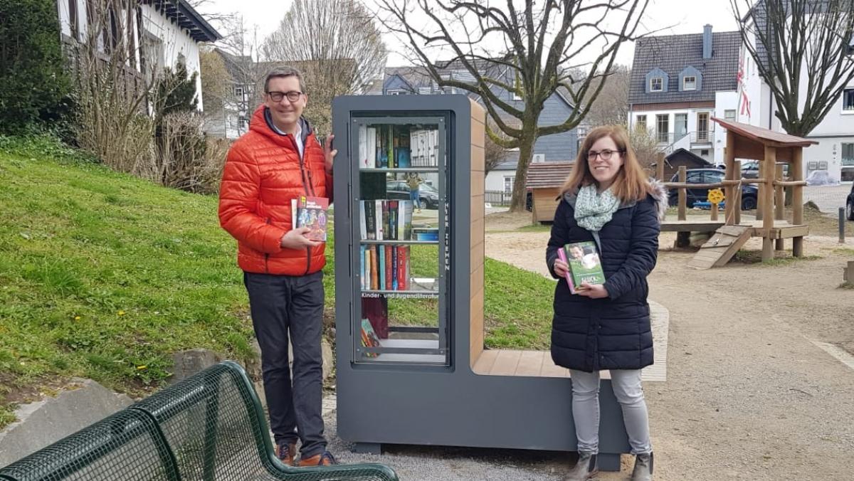 Thomas Bär, Erster Beigeordneter der Kreisstadt Olpe, und Friederike Baberg, Leiterin der Stadtbücherei, freuen sich über den neuen Bücherschrank im Weierhohl.  von privat