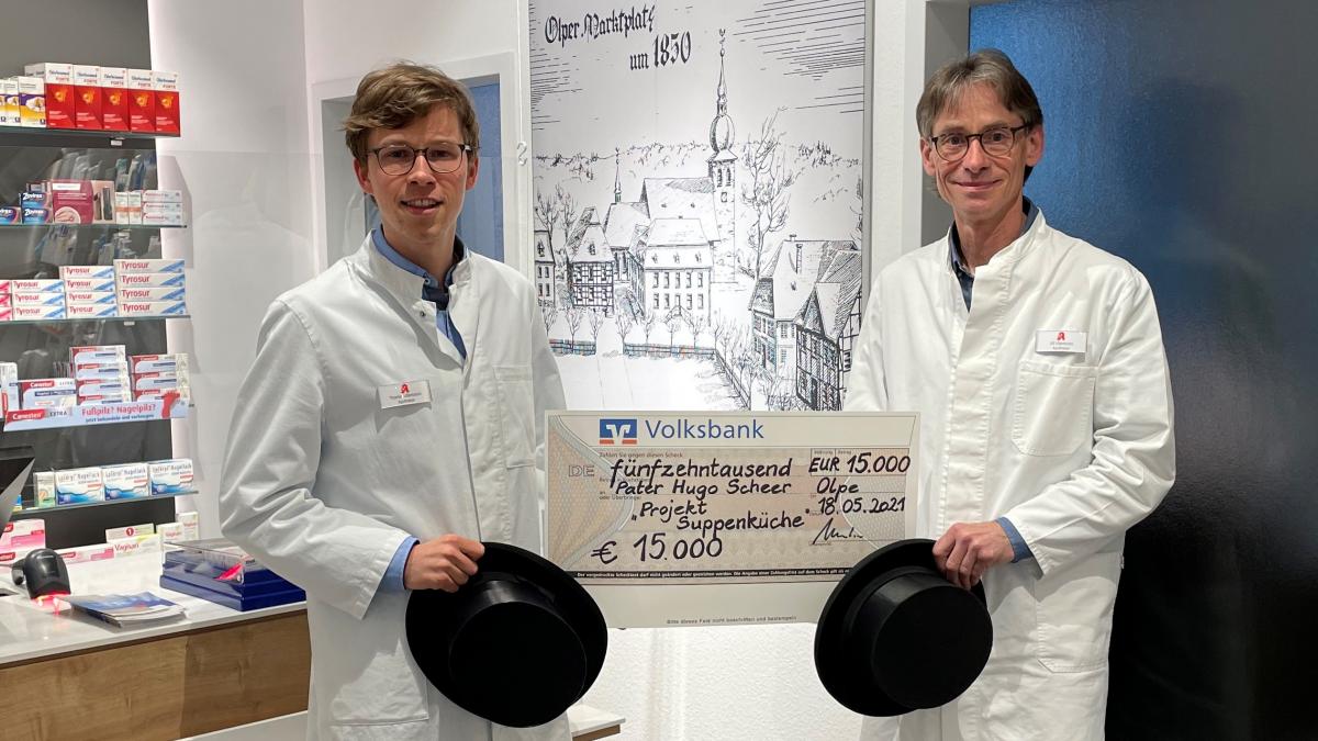 Die Olper Apotheker Ulf (rechts) und Thomas Ullenboom mit dem Spendenscheck für Pater Scheer. von privat