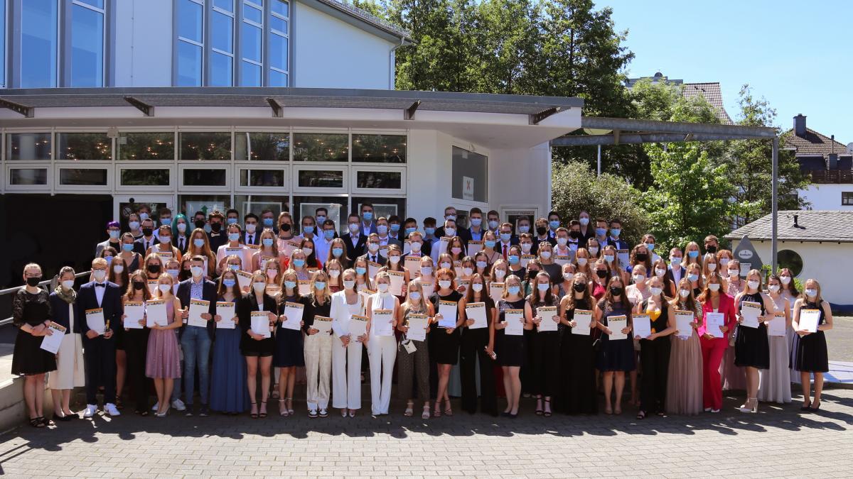 Die Schülerinnen und Schüler des Abiturjahrgangs 2021 am SFG zeigen stolz ihre Abiturzeugnisse. von privat