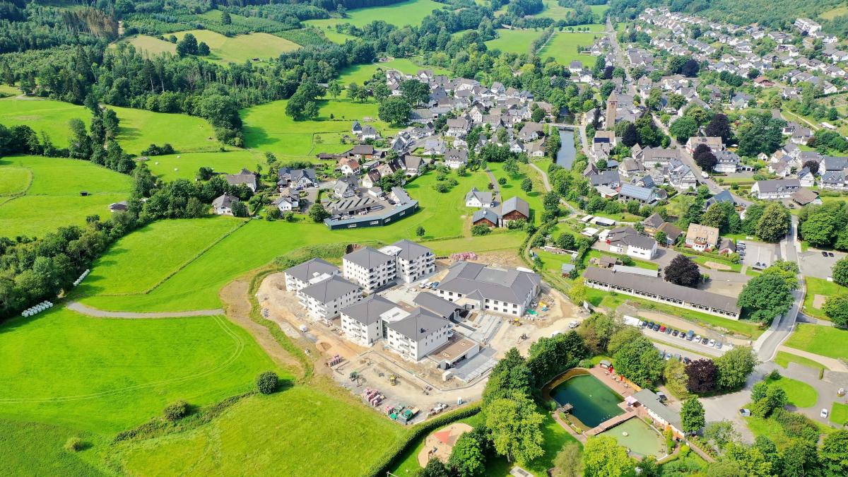 Eine aktuelle Luftbildaufnahme vom WohnGut in Saalhausen: Die einzelnen Gebäude-Komplexe fügen sich harmonisch in die Umgebung des Luftkurortes ein. von Volksbank Bigge-Lenne