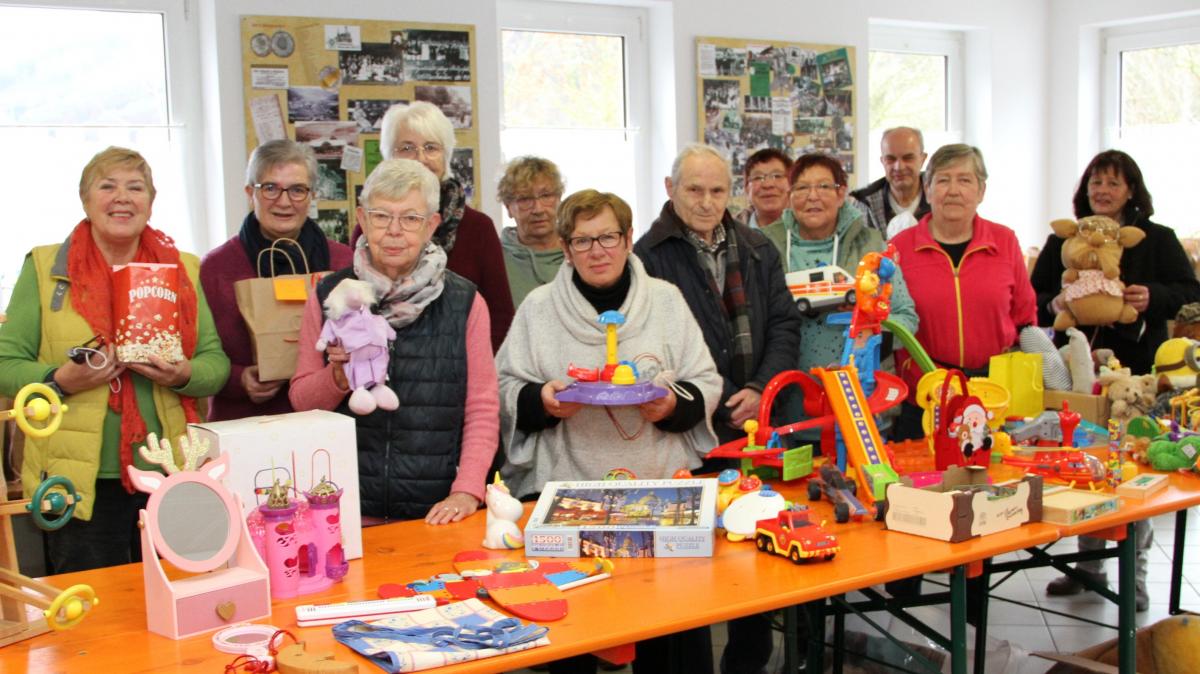 Ehramtlich, engagiert und mit Herzblut dabei: Geimpft und getestet stellen sich einige Mitglieder des Warenkorb-Teams kurz vor bevor die Türen geöffnet werden im Geschenkeraum zum Gruppenfoto auf. Sie freuen sich besonders auf die Kinder, die sich hier für sich und ihre Geschwister Geschenke aussuchen dürfen. von Kerstin Sauer