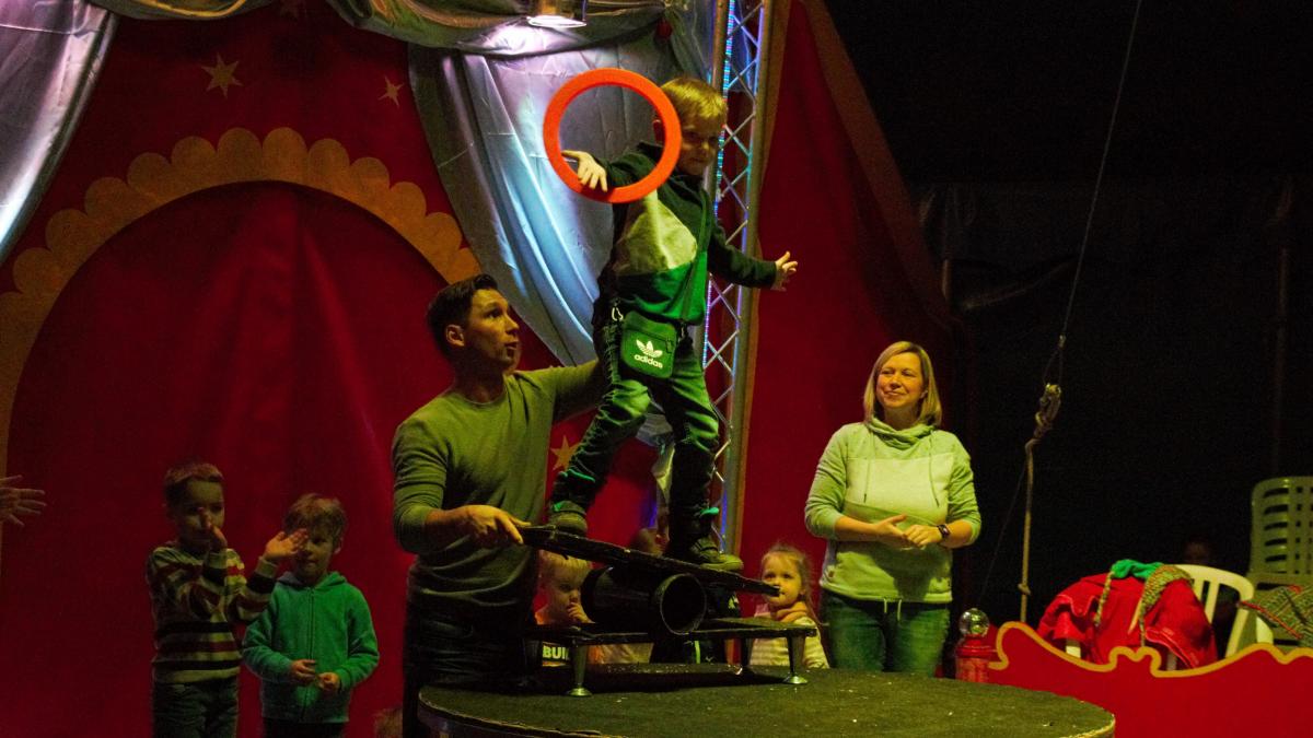 Bei der Nummer „Rolla Rolla“ zeigen die Kinder mit Hilfe von Zirkus-Chef Fernando Trumpf (vorne rechts), wie gut sie auf einem wackeligen Brett Gleichgewicht halten können - und drehen gleichzeitig einen Reifen am Arm. von Amy Gödde