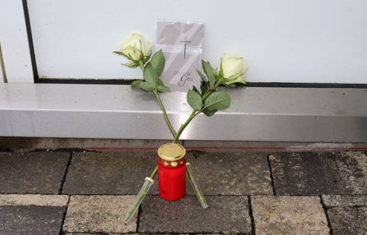 Eine Kerze und zwei Blumen zum Gedenken an die erschossenen Polizeibeamten. von Polizei Olpe