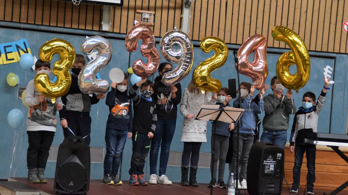 Mit Freude und berechtigtem Stolz zeigen die Schüler die Spendensumme von 32.392,46 Euro mit Ballons. von Nicole Voss