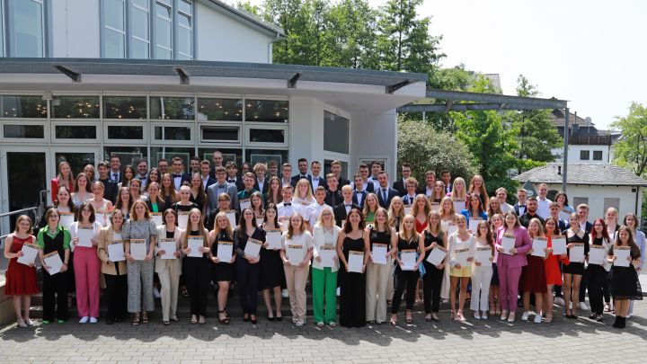 Die Schüler des Abiturjahrgangs 2022 am SFG zeigen stolz ihre Abiturzeugnisse.