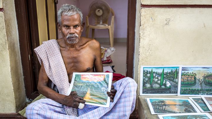 Ein von Lepra betroffener Mann verkauft selbstgemalte Bilder, um sich ein kleines Einkommen zu...