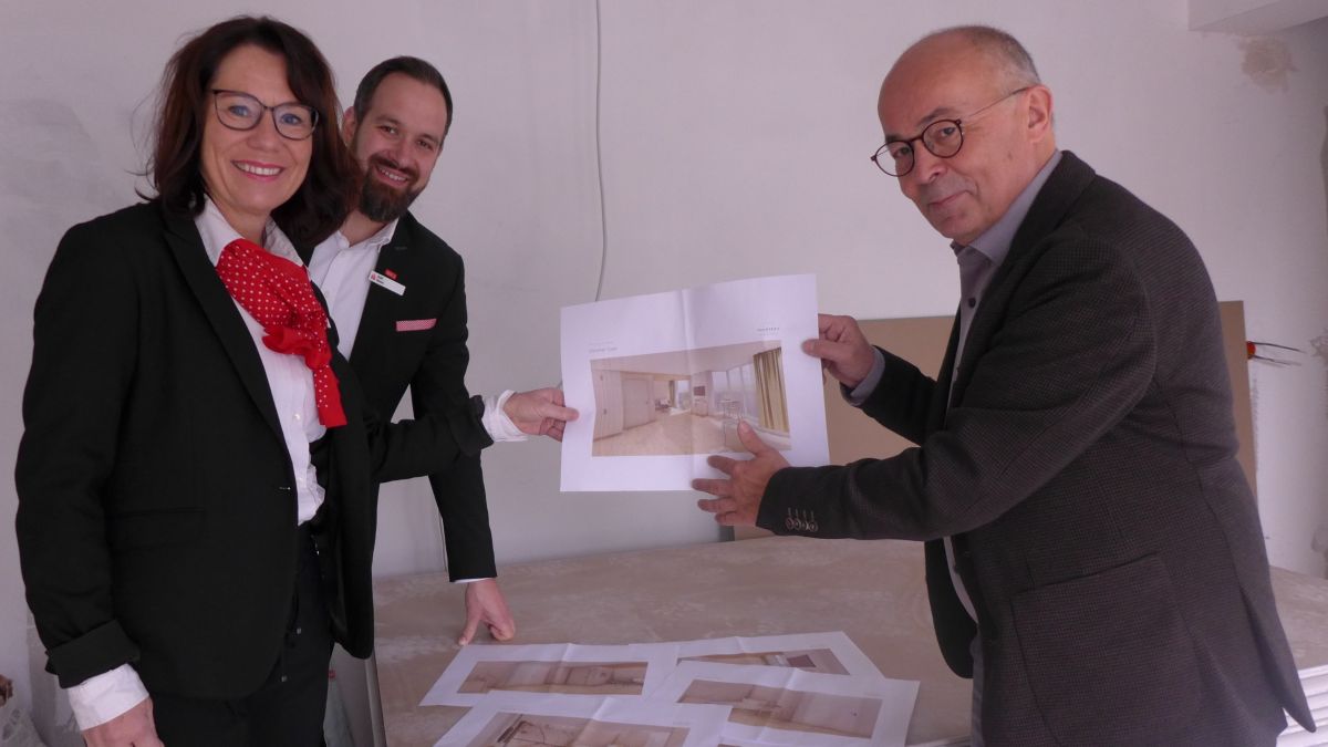 Der Geschäftsführer des Hospizvereins, Martin Schäfer, zeigt Ralf Sasse (Bereichsleiter Immobilien) und Christiane Reißner-Reichling (Firmenkundenberaterin) Entwürfe der künftigen Raumgestaltung. von Sparkasse