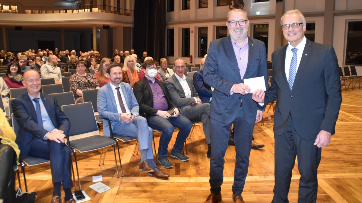 Bürgermeister Achim Henkel gratuliert dem Sängerkreisvorsitzenden Steffen Keller mit einem Flachgeschenk zum Jubiläum. von Nicole Voss