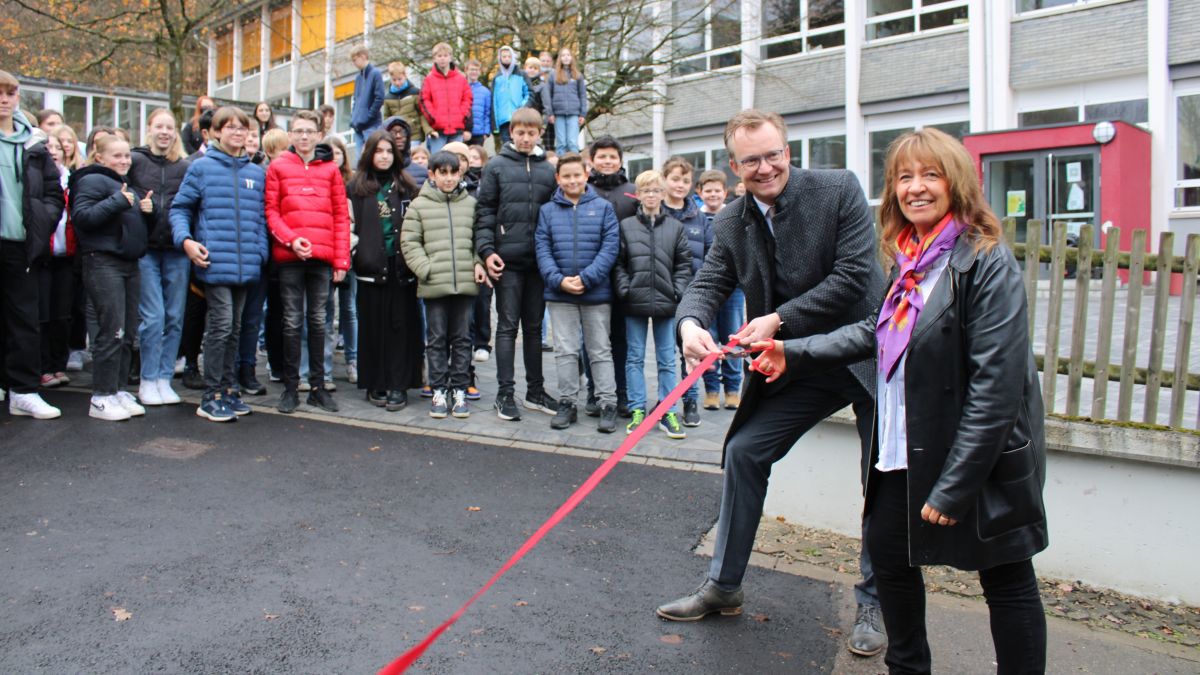 Schulleiterin Birgitta Pieters und Bürgermeister Tobias Puspas durchtrennten das Band zur Eröffnung des neuen Schulhofs und des sanierten D-Blocks am Gymnasium der Stadt Lennestadt. von Lorena Klein