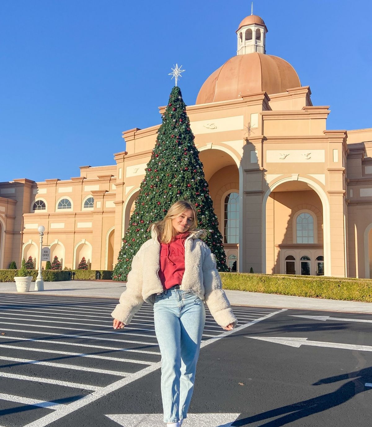 Elena vor einem Riesen-Weihnachtsbaum mit strahlend blauem Himmel und Sonnenschein: Die 16-jährige Altenhundemerin feiert Weihnachten in Texas. von privat