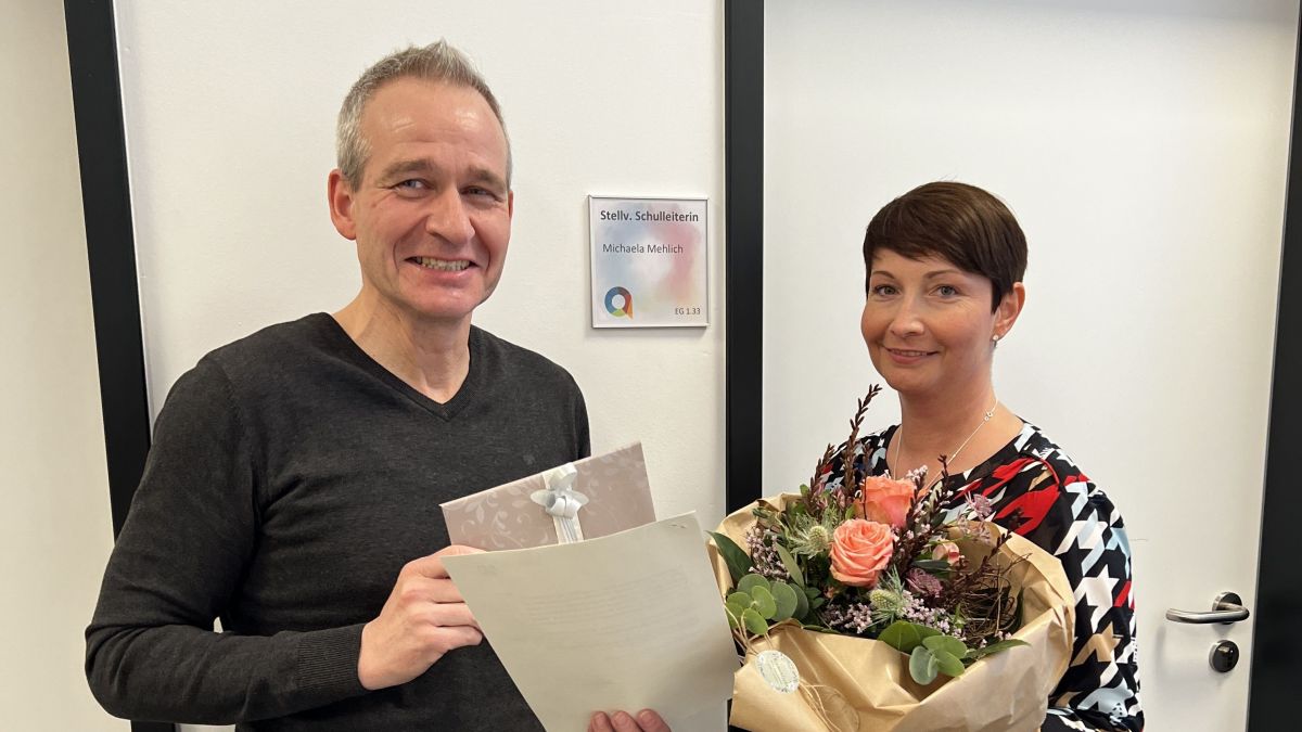Schulleiter Thorsten Vietor überreicht Michaela Mehlich das Schreiben der Bezirksregierung Arnsberg und einen Blumenstrauß. von privat