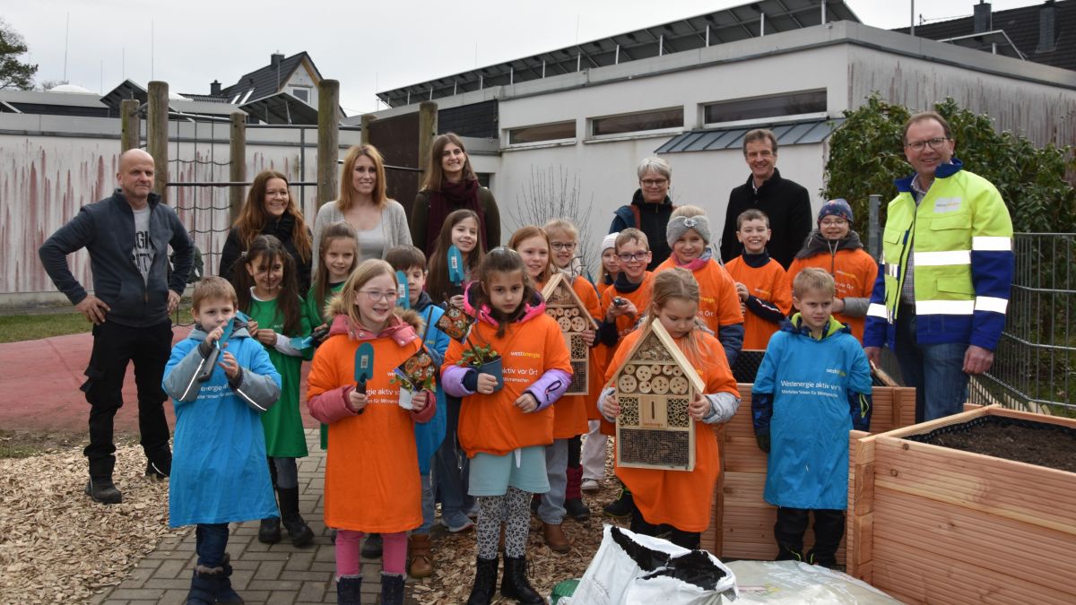 Kita- und Grundschulkinder mit ihren Gästen bei der Einweihung der Hochbeete: Martin Viedenz, Simone Herrendörfer, Carina Wache (stellv. Kita-Leitung), Natalie Wilde (Lehramtsanwärterin), Sabine Bock (Schulleiterin) und Bürgermeister Bernd Clemens (hinten, v.l.) sowie Achim Loos von Westenergie (r.). von privat