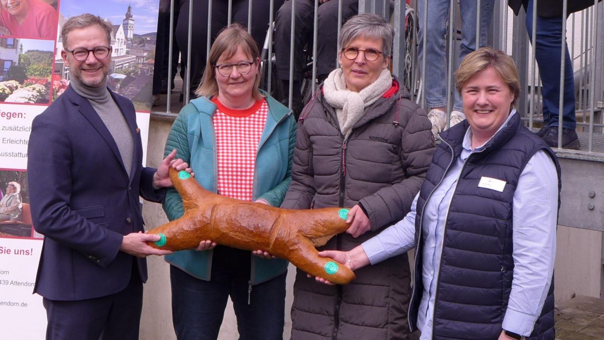 Symbolisch für die 200 Ostersemmeln überreichten die Vorstandsmitglieder des Fördervereins des Caritas-Zentrums Attendorn, Heinz-Jörg Reichmann, Anja Geuecke und Dagmar Langenohl (vorne, v.l.) eine übergroße Semmel, gespendet von Bäckermeister „Nelly“ König, an Ivonne Neu (vorne rechts). von privat