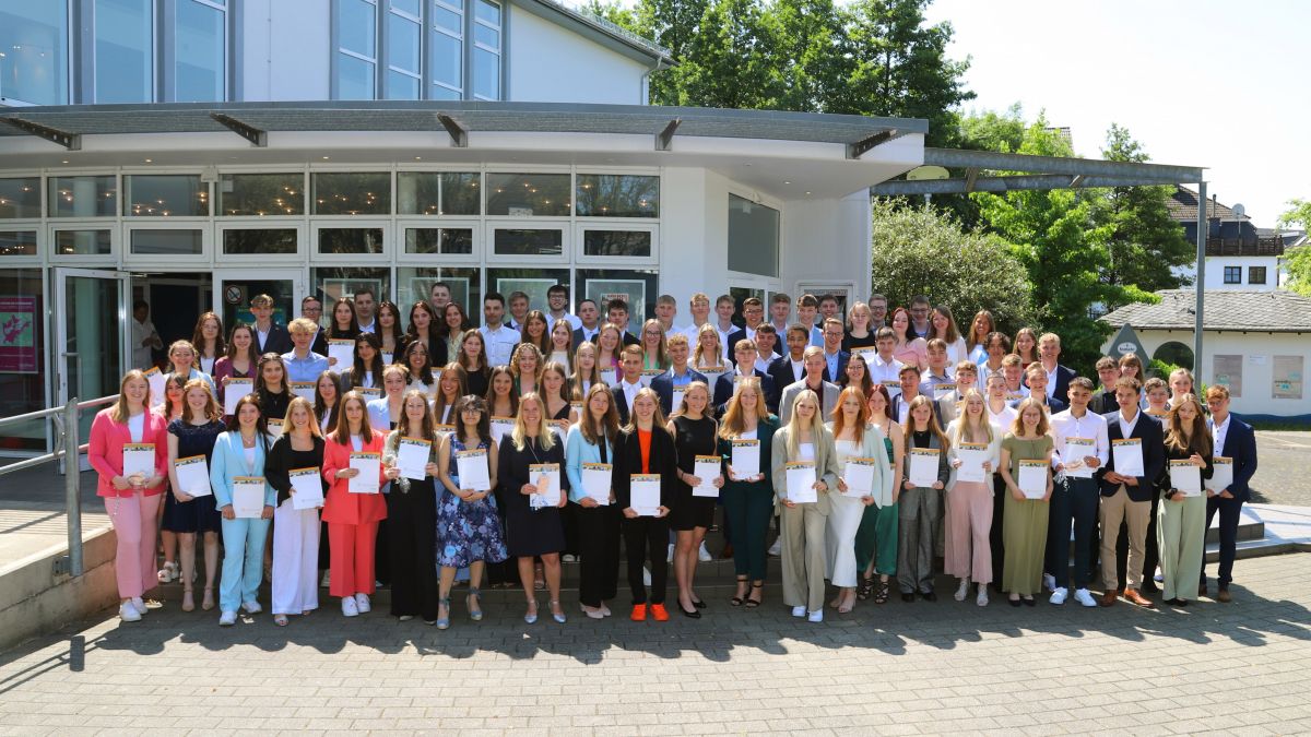 Die Schülerinnen und Schüler des Abiturjahrgangs 2023 am SFG zeigen stolz ihre Abiturzeugnisse. von St.-Franziskus-Schule / Julia Stamm-Ochel